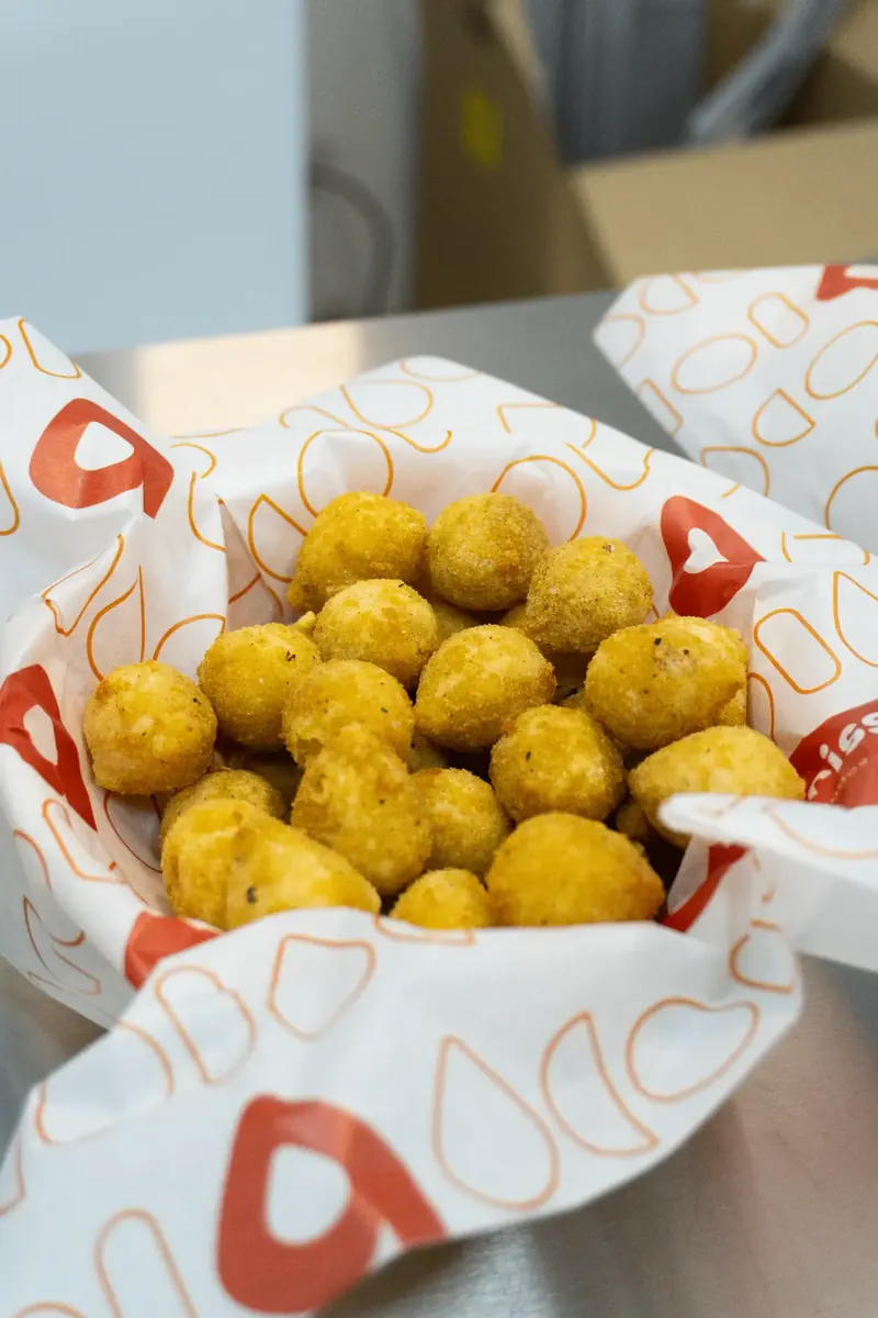 Coxinhas douradas servidas no papel com a estampa Brasileirisse