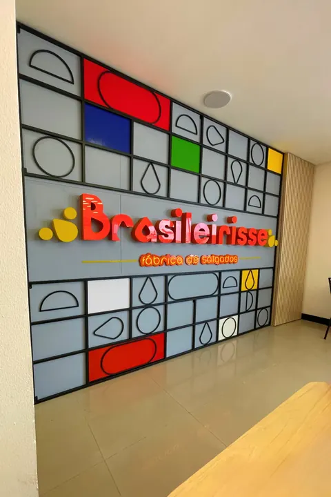 Parede colorida com o letreiro Brasileirisse, fábrica de salgados